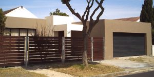 Charcoal horizontal slatted Aluzinc sectional door, and meranti fencing
