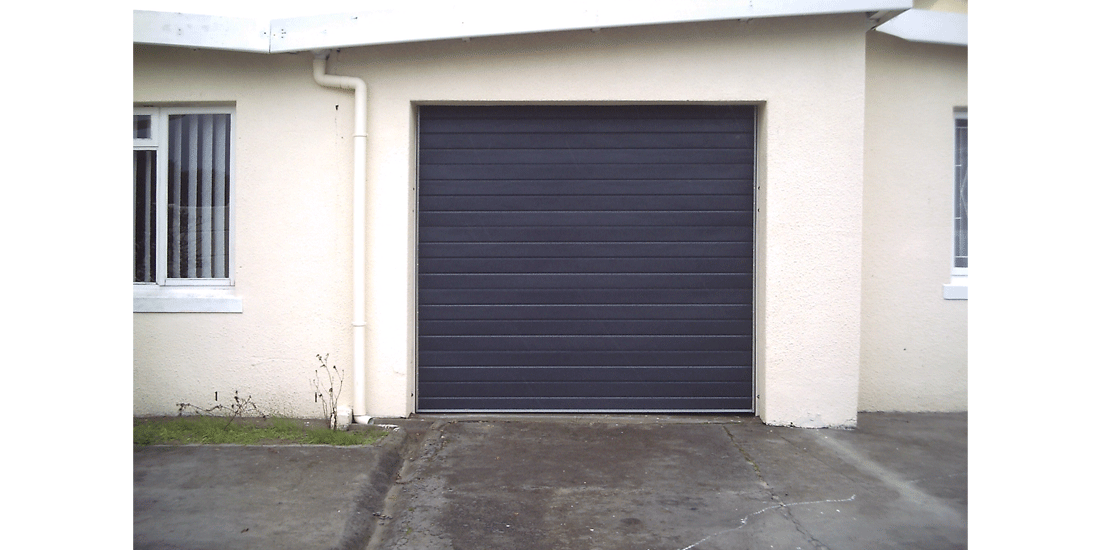 Single charcoal horizontal slatted aluzinc tip up door